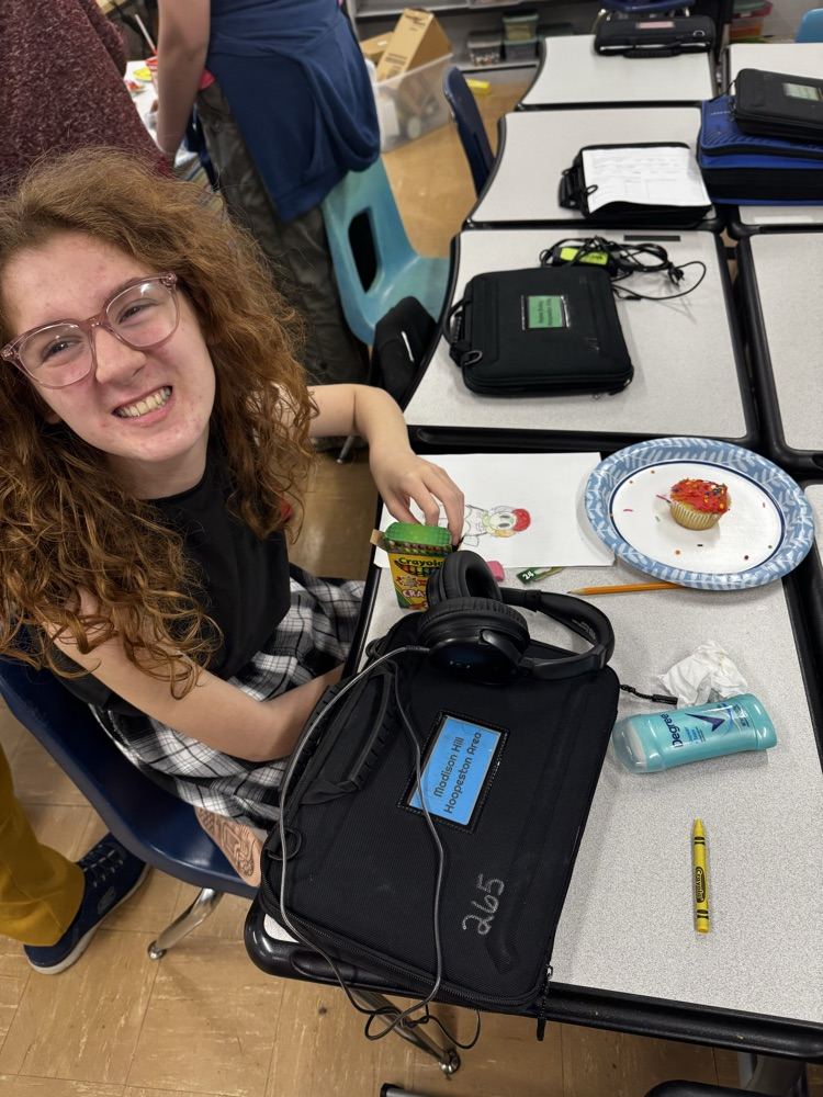 a student smiling with a cupcake 