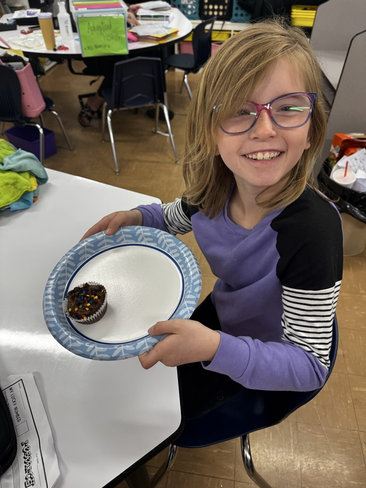 a girl student smiling with a cupcake