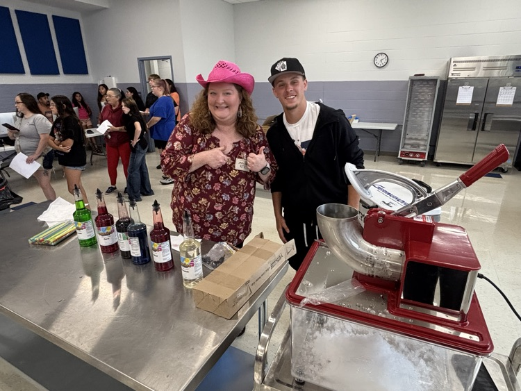 Teacher and volunteer make sno cones.