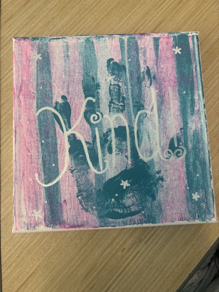 canvas with “kind” painted on it