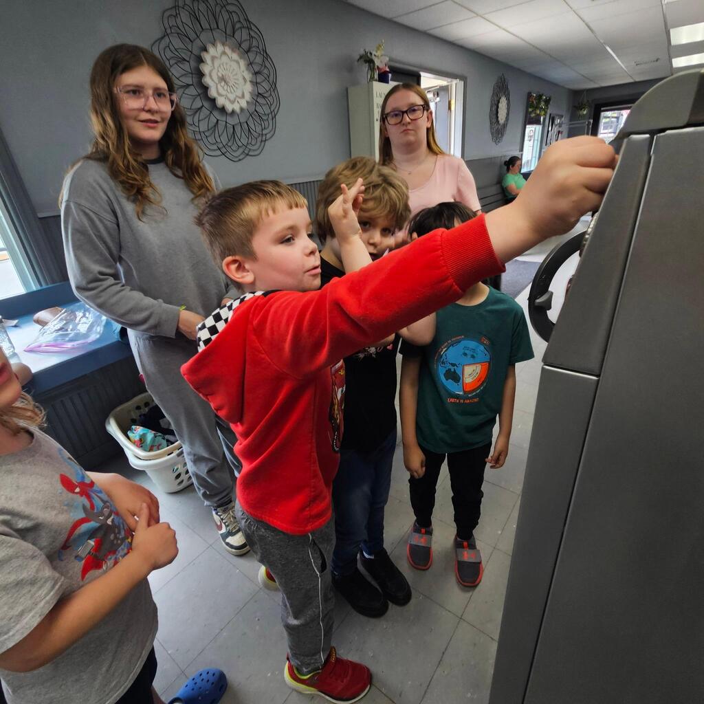 Elementary teacher Mrs. Cross has another “community integration field trip” to share! These trips allow students to explore some of the community helper roles they have been learning about in the classroom. Students visited the laundry mat in the Village! The kiddos made change, put coins into the washer, poured detergent, and watched the laundry spin! They walked to the store and purchased a drink, and then returned when the wash was done and put the blankets into the dryer. They did a great job, and they had an awesome time out in the community! Thanks for sharing, Mrs. Cross! 