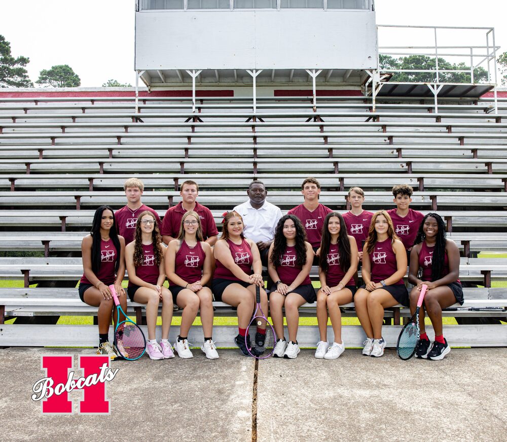 Group photo of the 2026–2027 Hope High School Tennis team and coach posed on stadium bleachers, with several players holding tennis rackets.