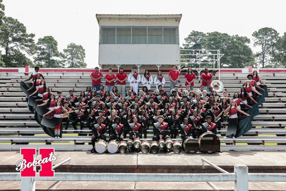 Group photo of the 2026–2027 Hope High School Band on stadium bleachers, including student musicians, percussion, drum majors, color guard members, and band staff.