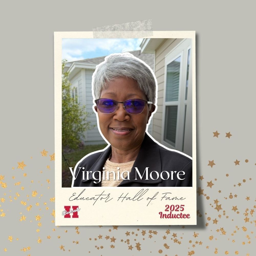 Portrait of Virginia Moore smiling outdoors with short gray hair, wearing blue-tinted glasses, a cream top, and a dark blazer. The image is framed with a cream-colored border that reads ‘Virginia Moore — Educator Hall of Fame 2025 Inductee.’ Gold star accents decorate the background.