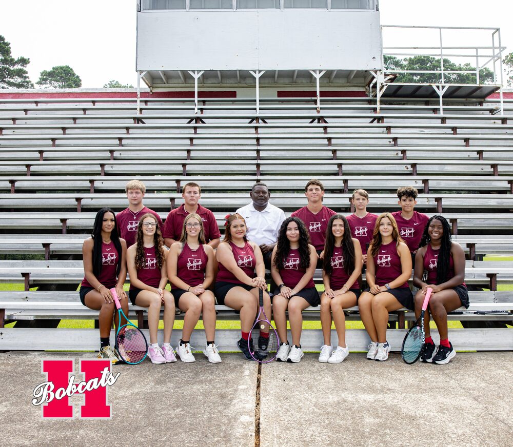 Group photo of the 2026–2027 Hope High School Tennis team and coach posed on stadium bleachers, with several players holding tennis rackets.