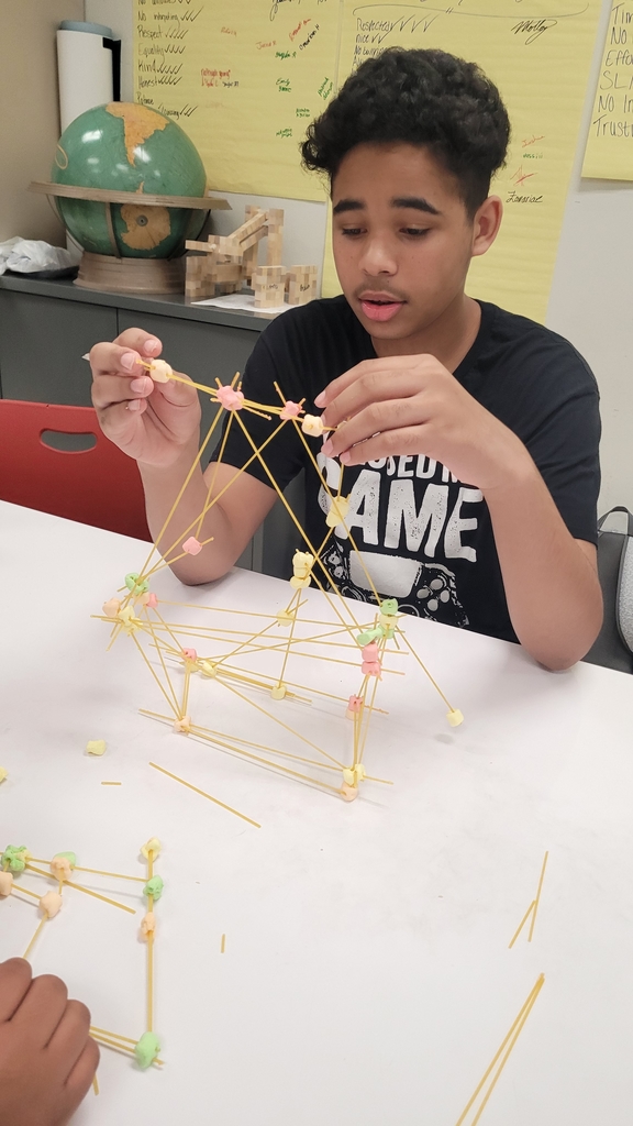 student adding more pasta to his existing Tower