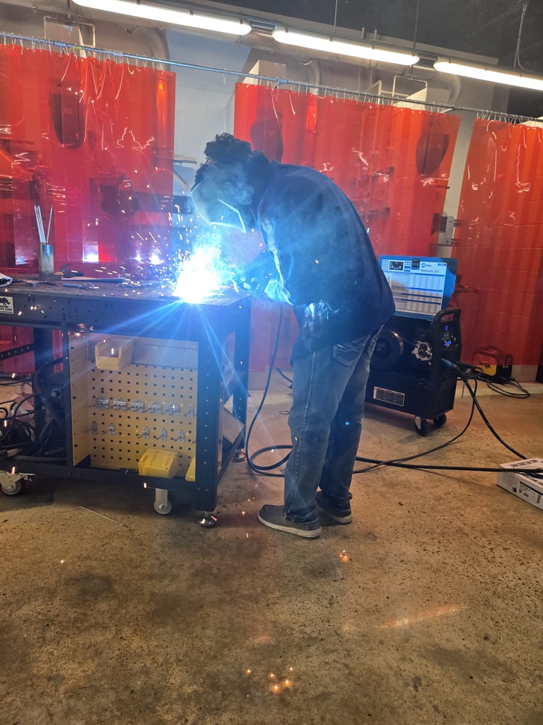 Hope High School agriculture students wearing welding helmets and protective gear practice MIG welding using new welding equipment in the Ag Department workspace.