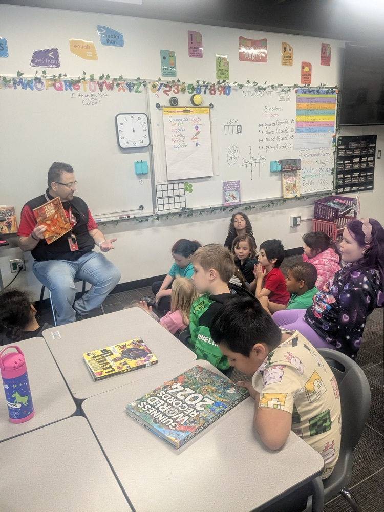 principal Ihde reading to 2nd graders