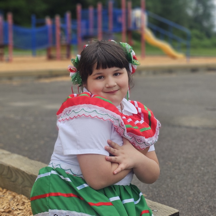 student outside near playground smiling 