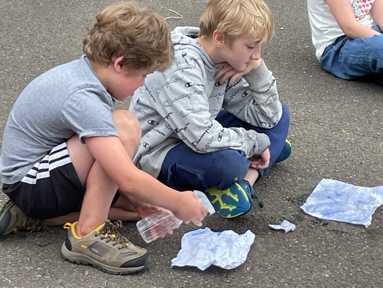 students spritzing water onto crumpled paper