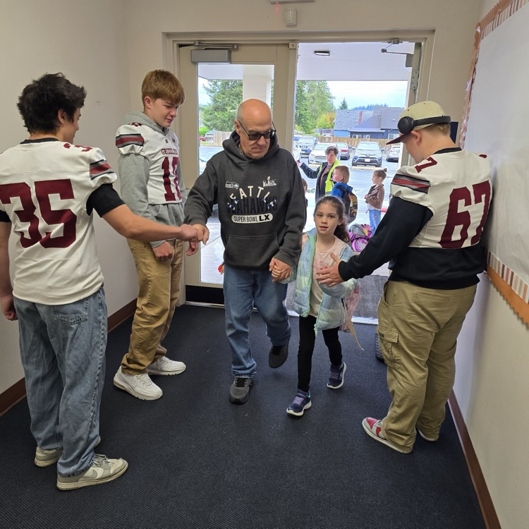 football players greeting students in school