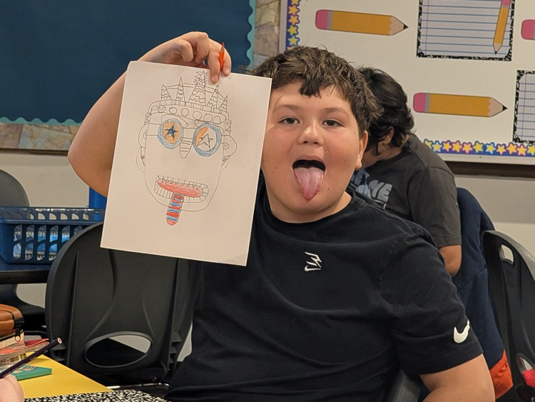 Mayan mask alongside student striking a similar pose