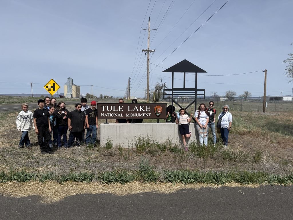 Students standing next to a sign. 