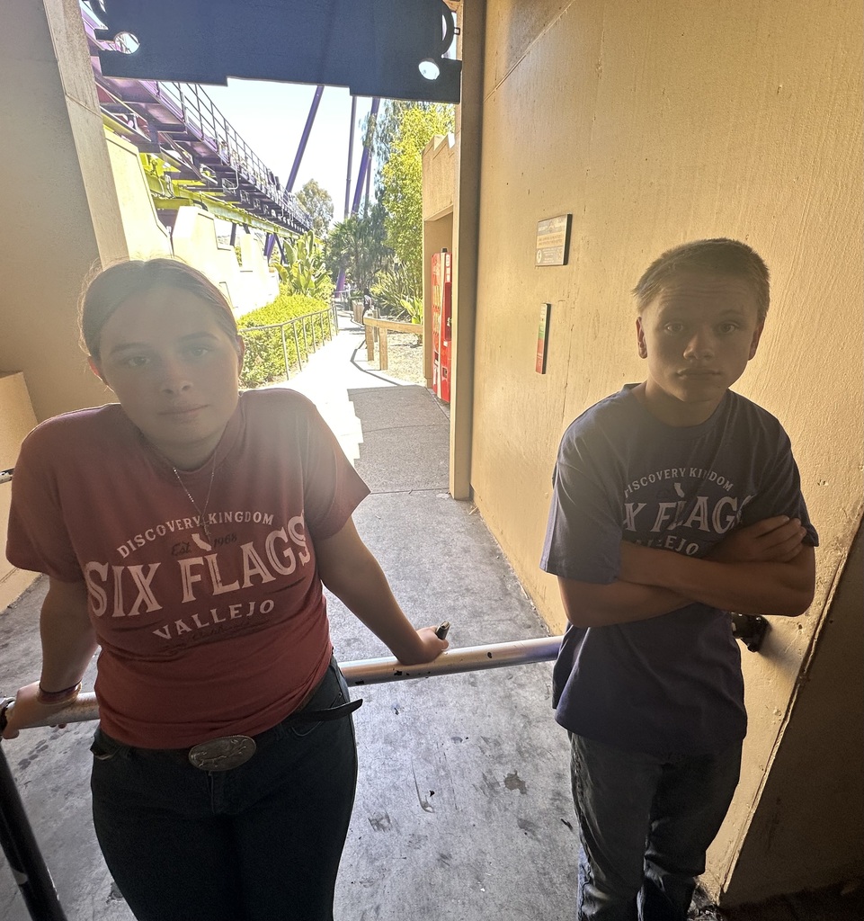 Students standing in line waiting to get on a ride at Six Flags. 