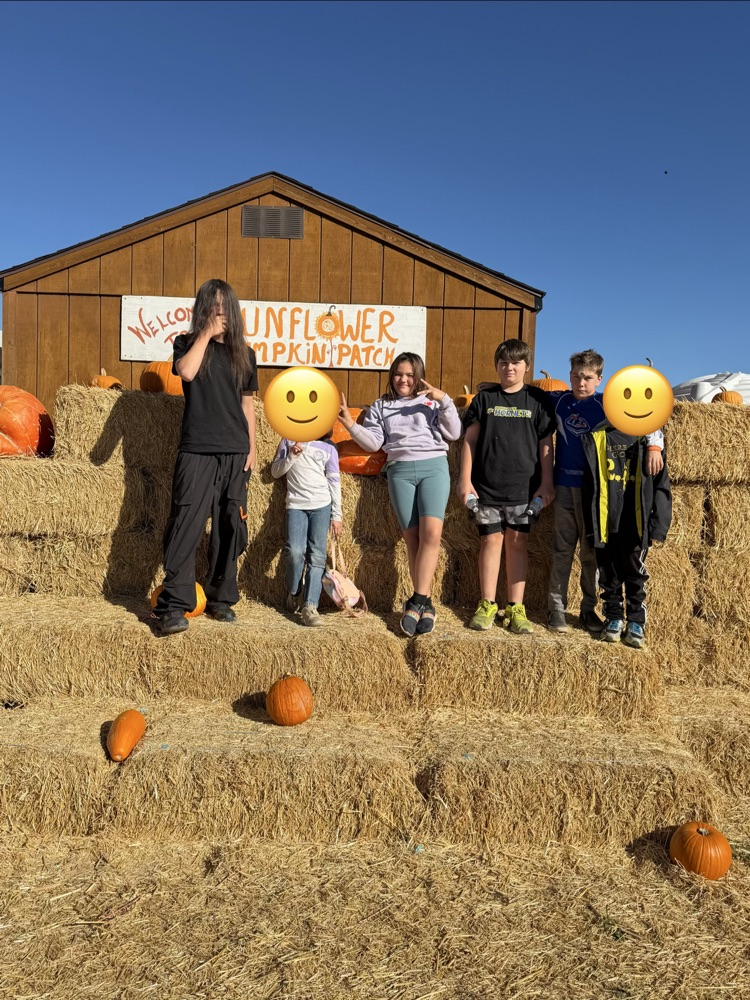 Student’s standing on hay at the pumpkin patch.