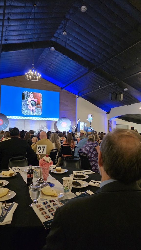 Three photos from the Region 10 ESC Teacher of the Year celebration at Southfork Ranch. The first shows the event program with a colorful retro design reading “2027 Texas Teacher of the Year: The Greatest Hits.” The second shows attendees seated at banquet tables facing a stage and large presentation screen. The third shows Howe ISD Teacher of the Year Stephanie Burge standing with her principal, Paula Lashley, in front of a decorated photo backdrop featuring colorful balloons, music notes, and records.