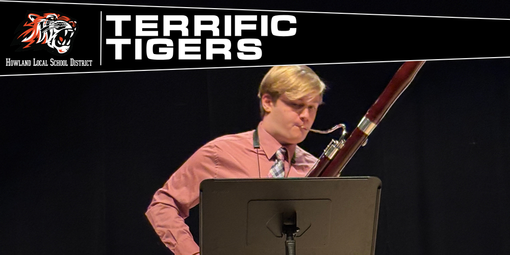 A student bassoonist performs as a soloist in front of a seated concert band during a live performance.
