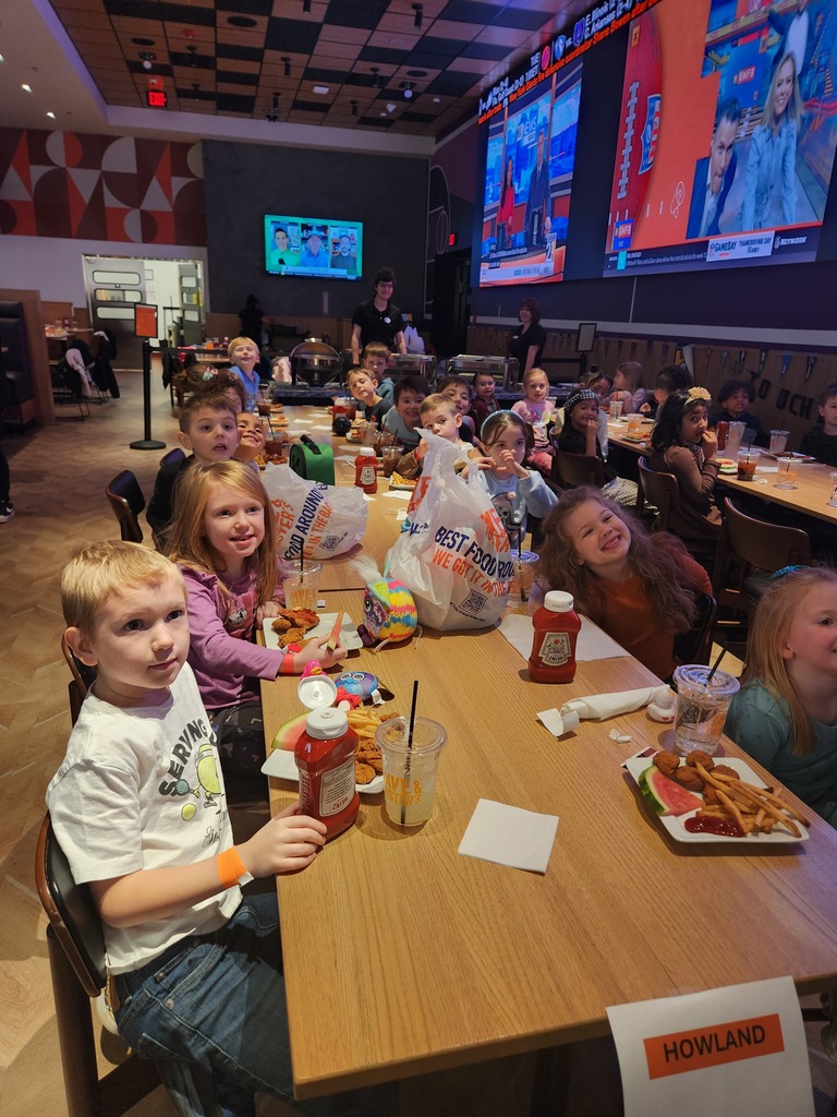 Howland Springs students smiling and playing arcade games together during a Dave & Buster’s reward trip.