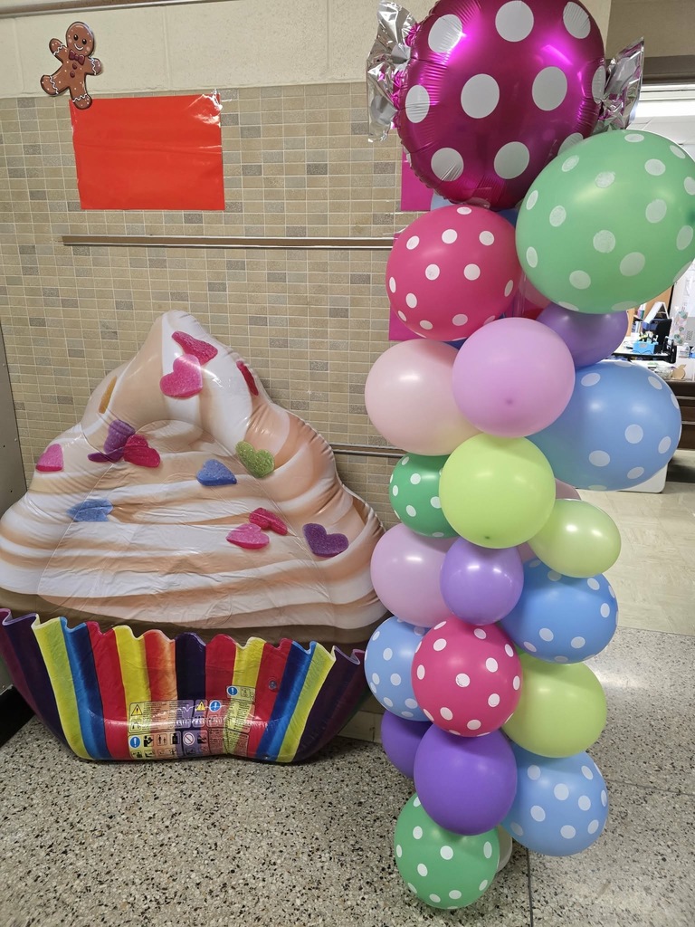 Candy Land-themed literacy night with students and families participating in reading activities, colorful game stations, and candy-inspired decorations throughout the school.