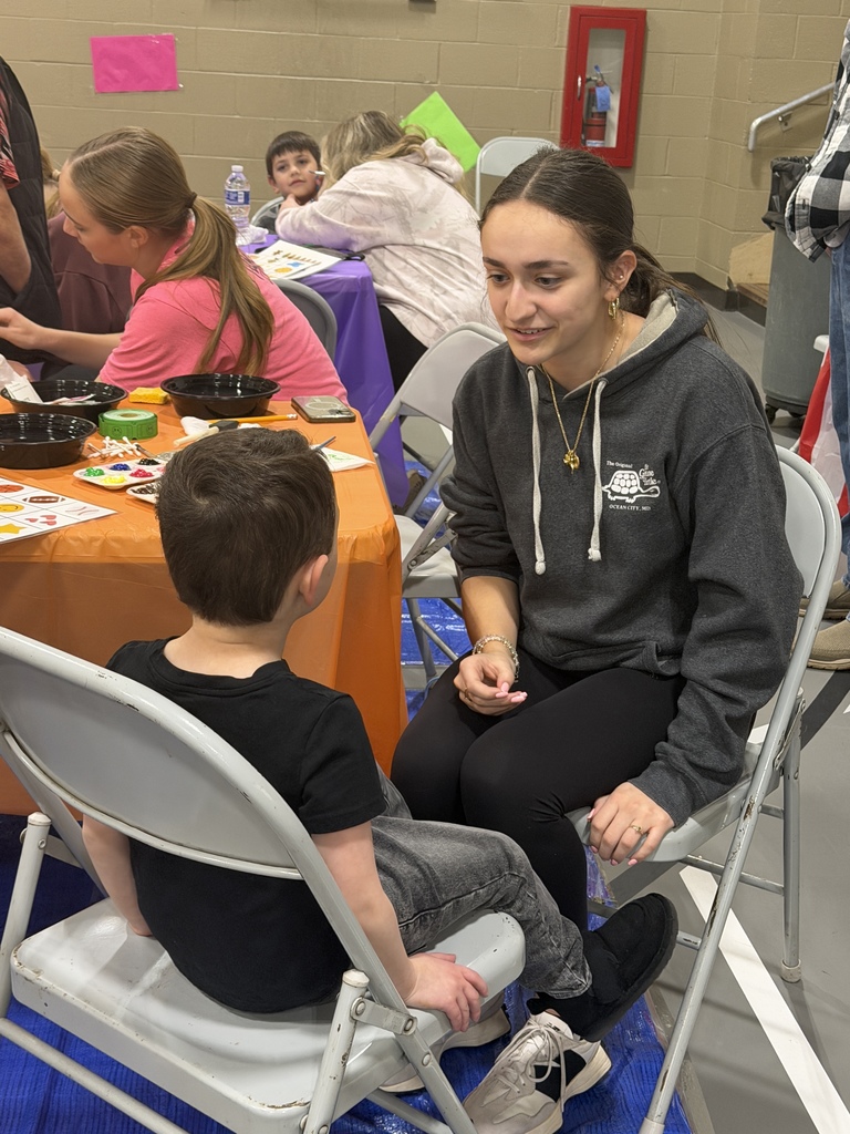 Candy Land-themed literacy night with students and families participating in reading activities, colorful game stations, and candy-inspired decorations throughout the school.