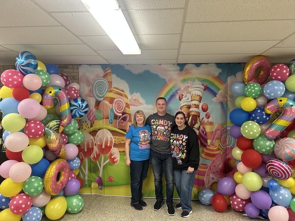 Candy Land-themed literacy night with students and families participating in reading activities, colorful game stations, and candy-inspired decorations throughout the school.