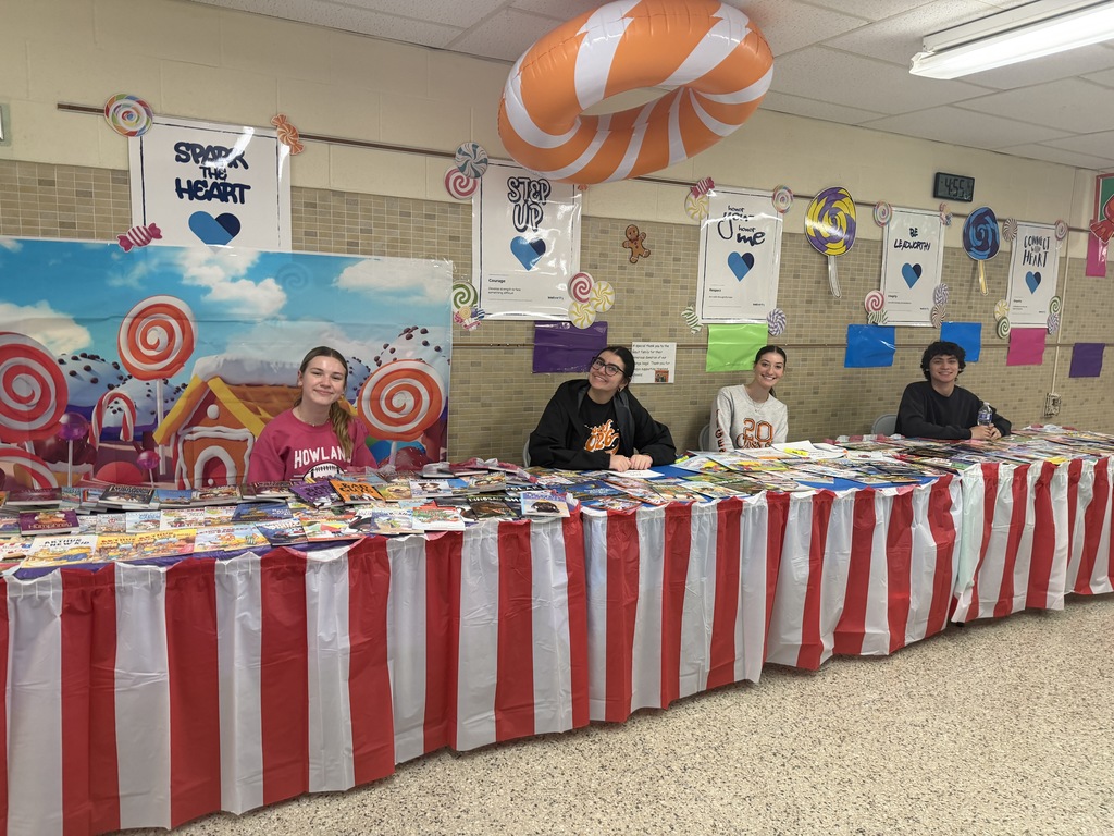 Candy Land-themed literacy night with students and families participating in reading activities, colorful game stations, and candy-inspired decorations throughout the school.