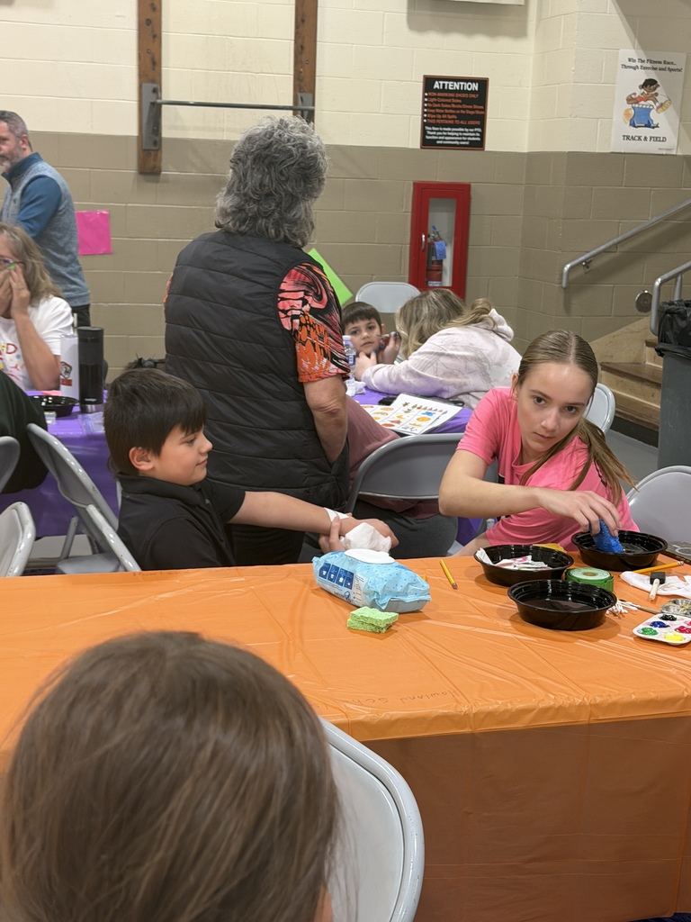Candy Land-themed literacy night with students and families participating in reading activities, colorful game stations, and candy-inspired decorations throughout the school.