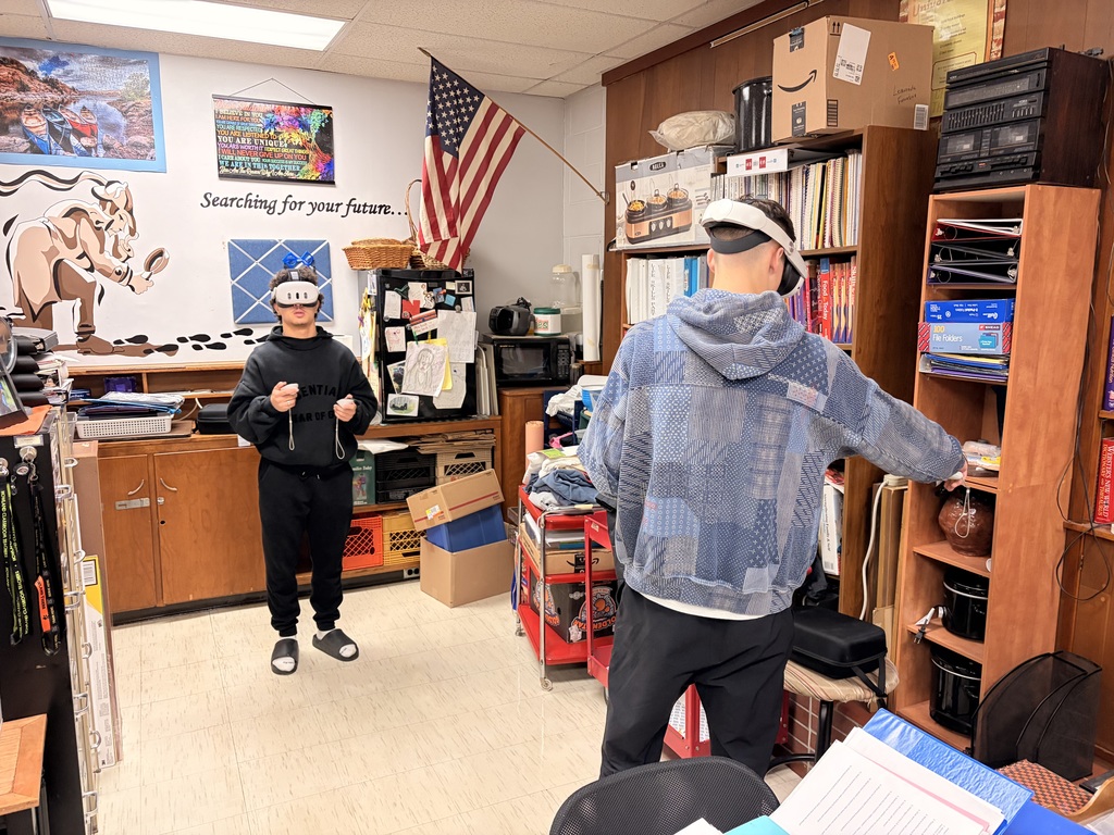 Students wearing virtual reality headsets and participating in simulated culinary or workplace environments in a classroom setting.