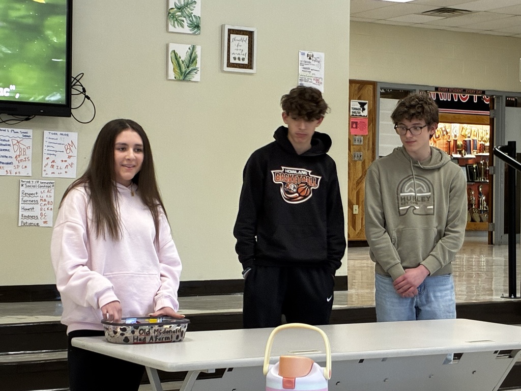 Students performing a nursery rhyme in Spanish while interacting with sensory stations created by classmates.