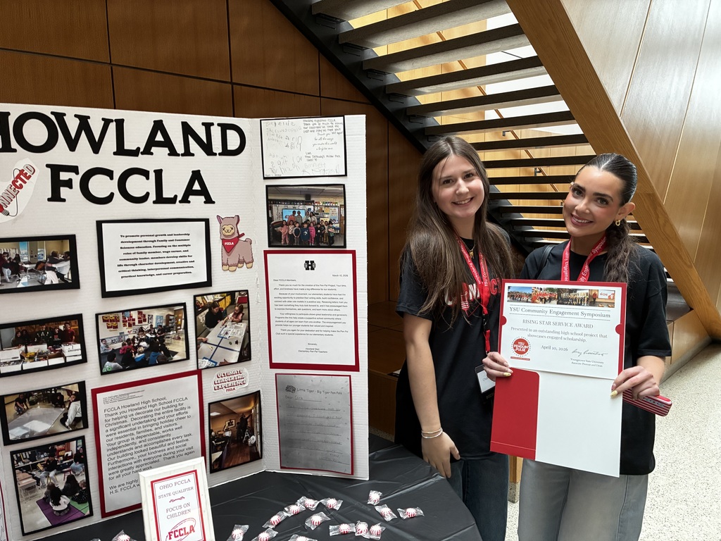  Two students holding award at the YSU Community Engagement Symposium