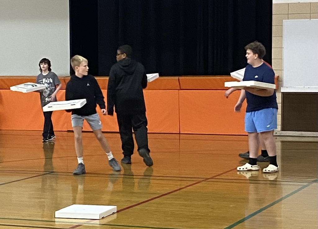 Students cheering and participating in games during a school pep assembly