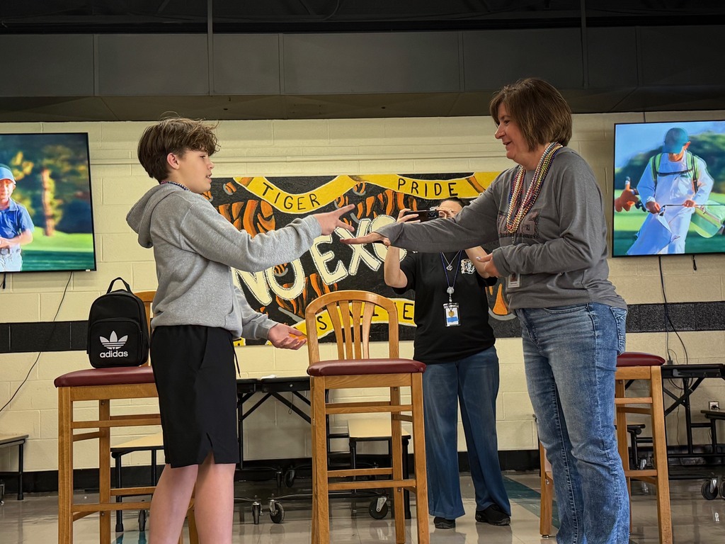 Students cheering and participating in games during a school pep assembly