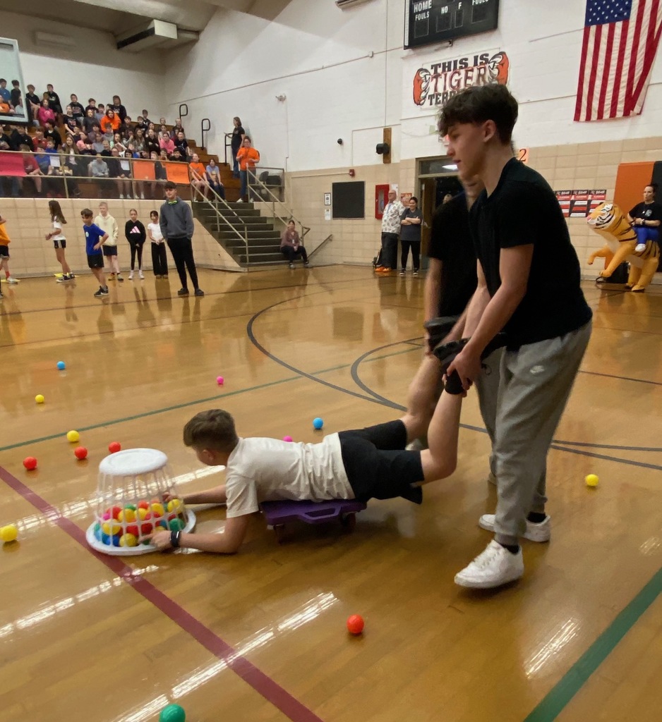 Students cheering and participating in games during a school pep assembly