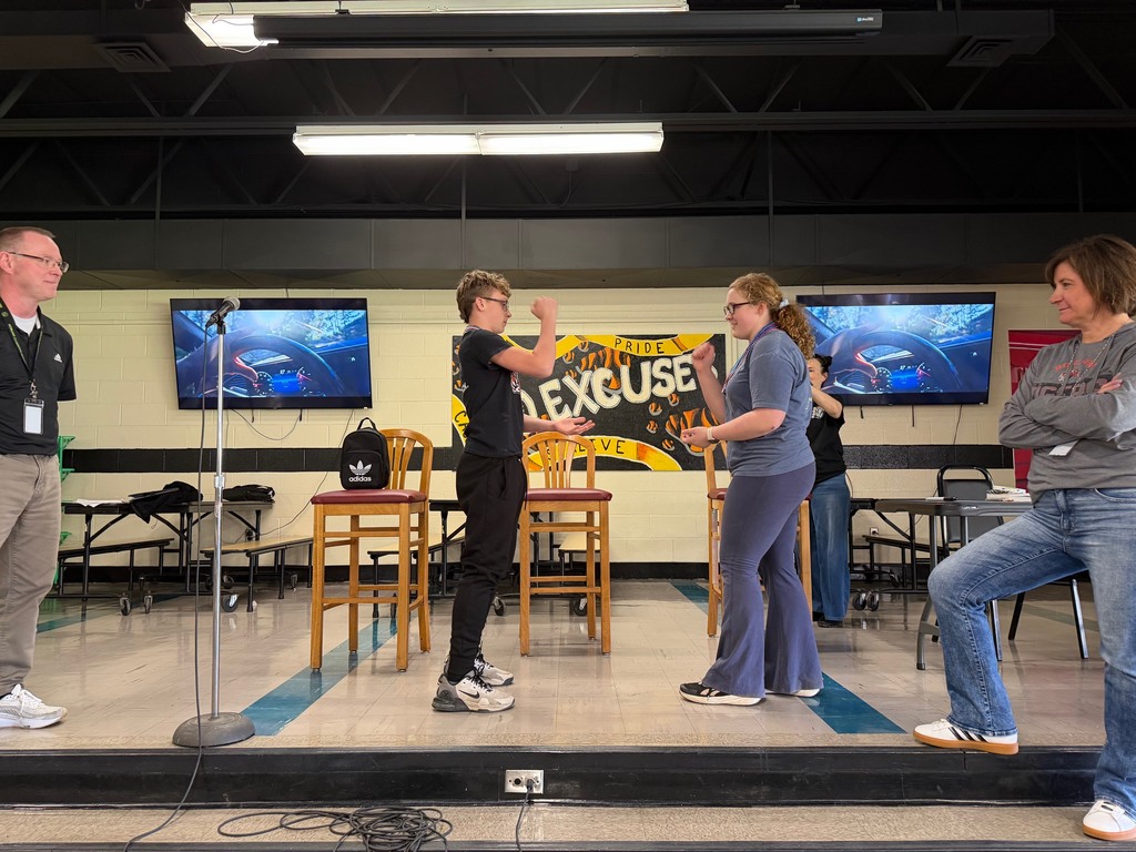 Students cheering and participating in games during a school pep assembly
