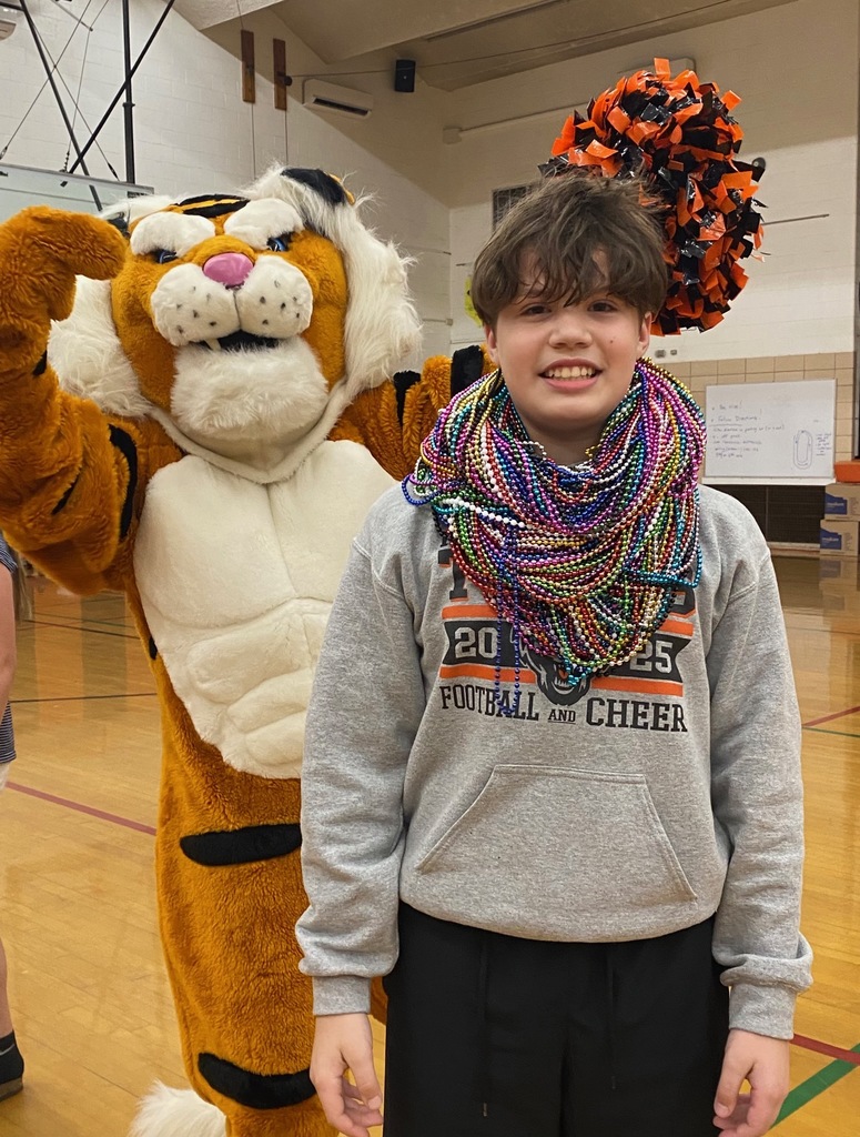 Students cheering and participating in games during a school pep assembly