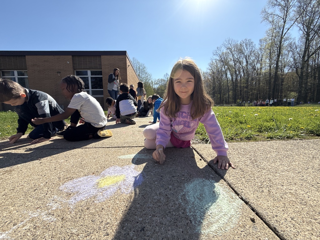 Students celebrating Earth Day outside, touring the Tiger Den, making bird seed, drawing with chalk, painting rocks, and playing with parachutes.