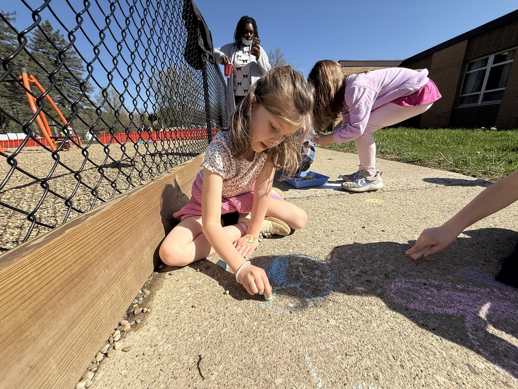 Students celebrating Earth Day outside, touring the Tiger Den, making bird seed, drawing with chalk, painting rocks, and playing with parachutes.