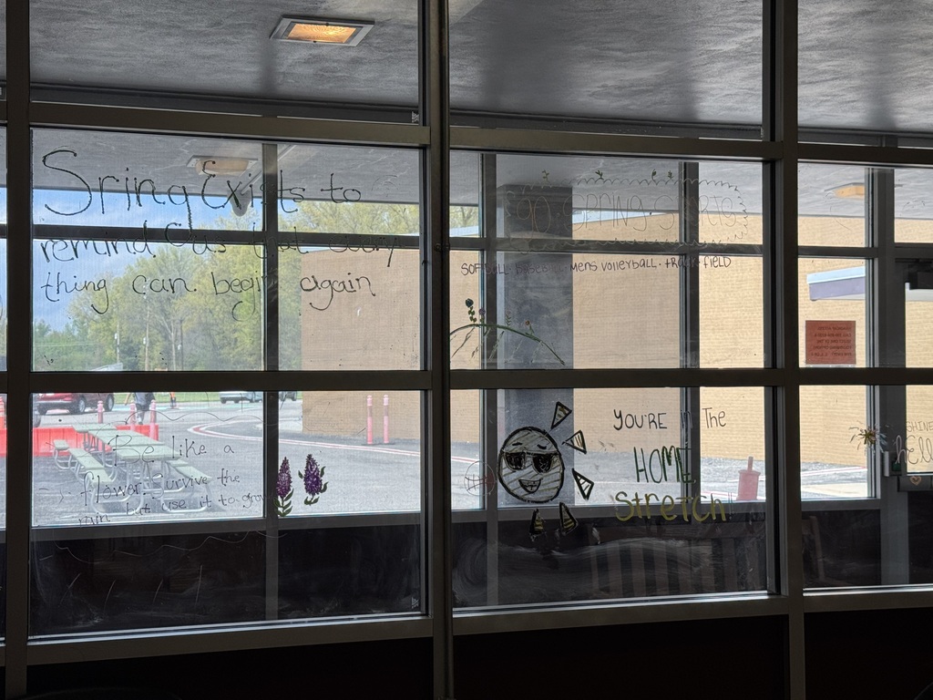 Students from the Health, Safety, and Wellness Club decorate school windows with colorful artwork and positive messages before summer break.