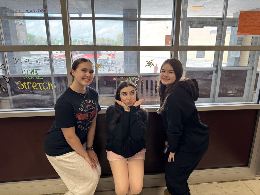 Students from the Health, Safety, and Wellness Club decorate school windows with colorful artwork and positive messages before summer break.