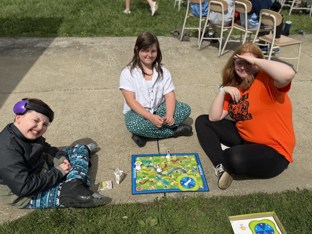 Howland High School seniors in orange shirts volunteer throughout the community during Senior Day of Service, helping at schools, parks, and local organizations.
