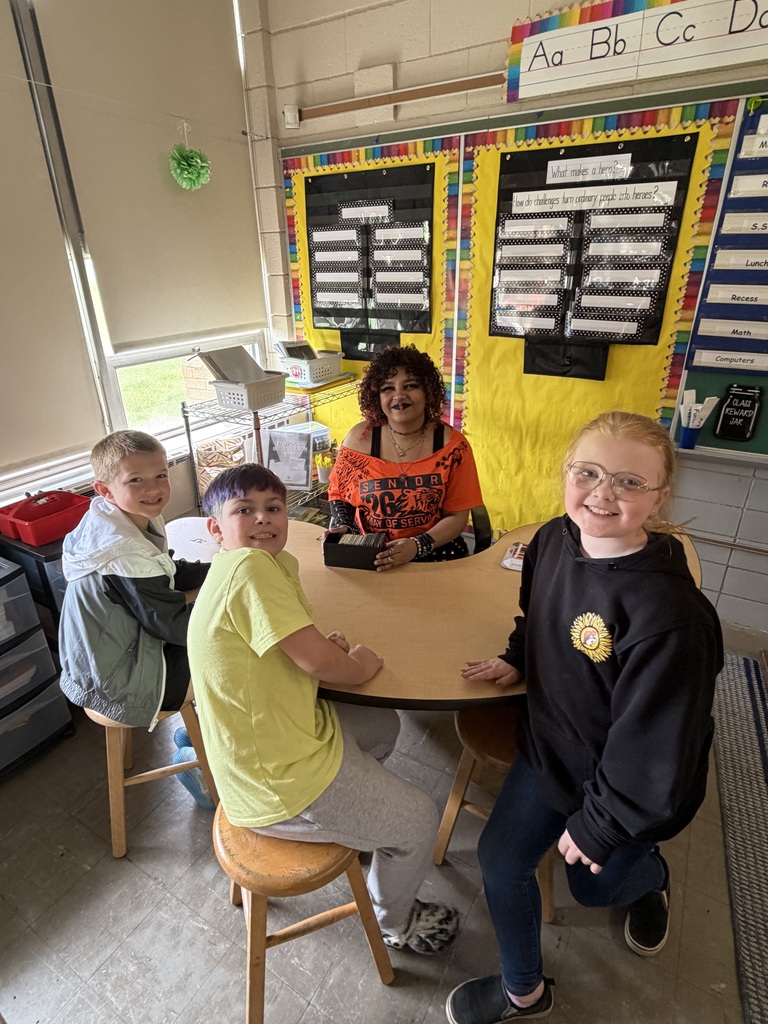 Howland High School seniors in orange shirts volunteer throughout the community during Senior Day of Service, helping at schools, parks, and local organizations.