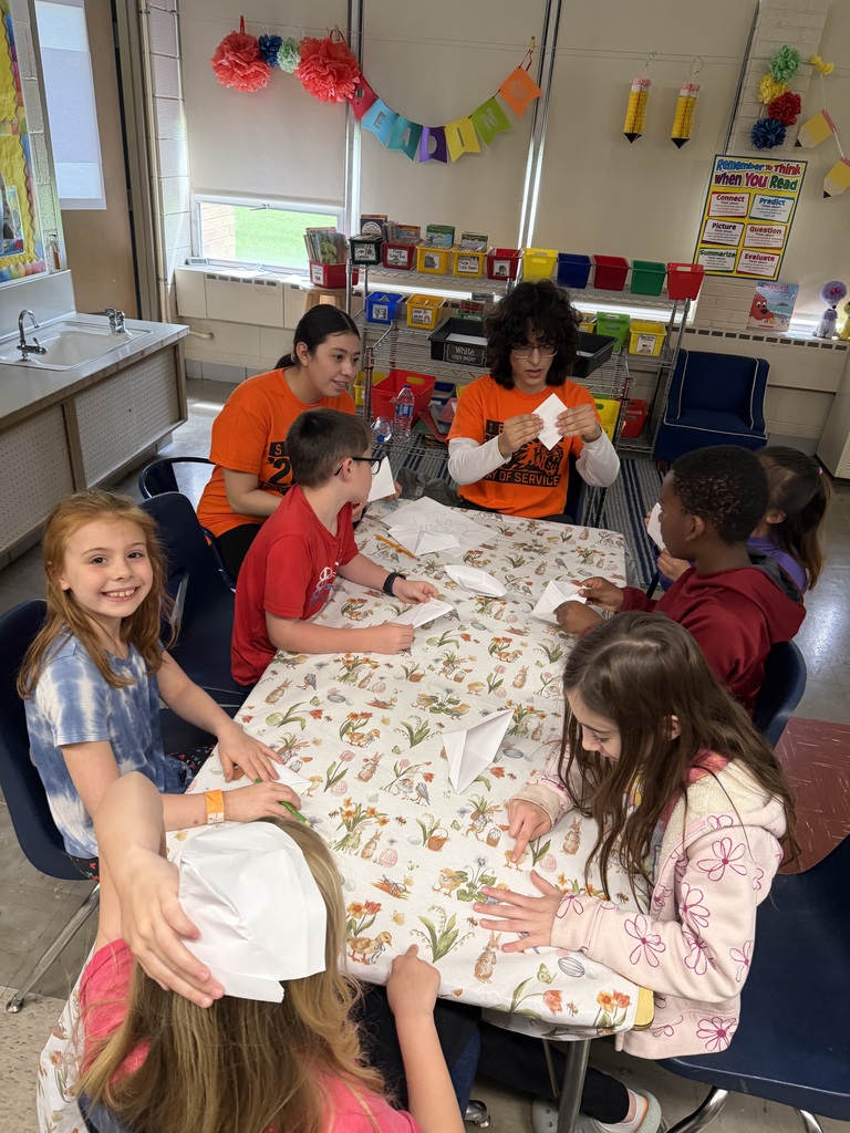 Howland High School seniors in orange shirts volunteer throughout the community during Senior Day of Service, helping at schools, parks, and local organizations.