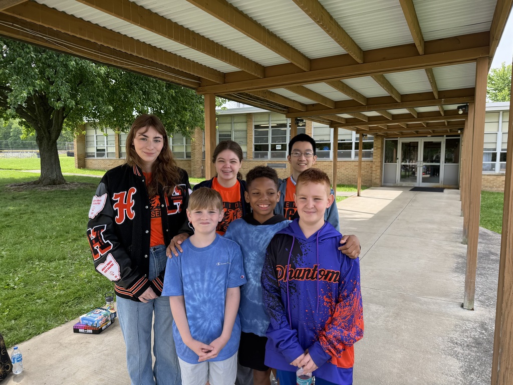 Howland High School seniors in orange shirts volunteer throughout the community during Senior Day of Service, helping at schools, parks, and local organizations.