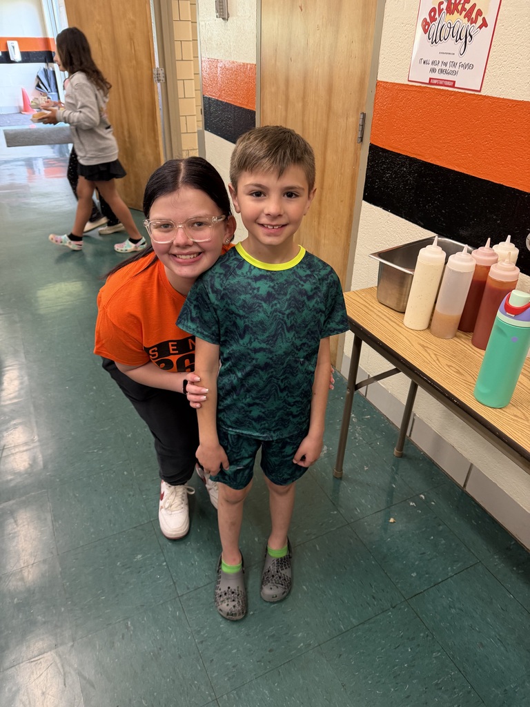 Howland High School seniors in orange shirts volunteer throughout the community during Senior Day of Service, helping at schools, parks, and local organizations.