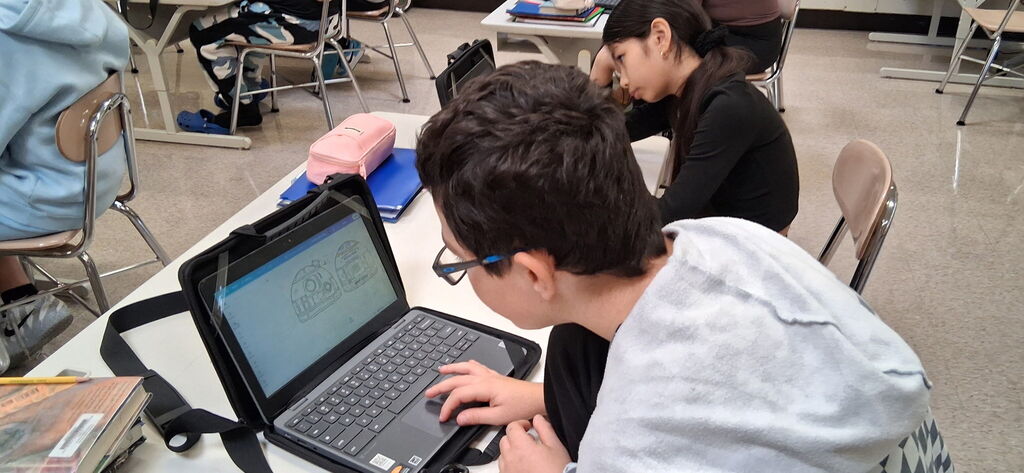 Howland Intermediate School students participate in Ohio Code Scholar, with Kenley and Ryeliegh working on Arduino wiring and audio while classmates develop ideas for 3D designs.