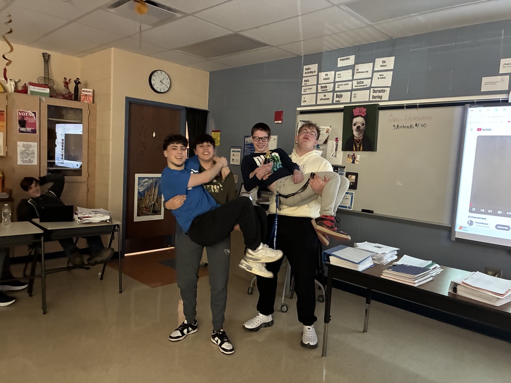Student posing with their winning film project award, smiling at the camera