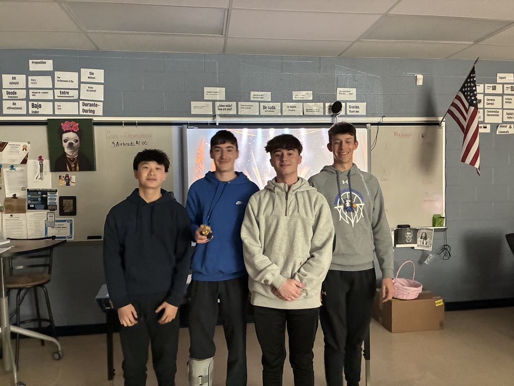 Student posing with their winning film project award, smiling at the camera