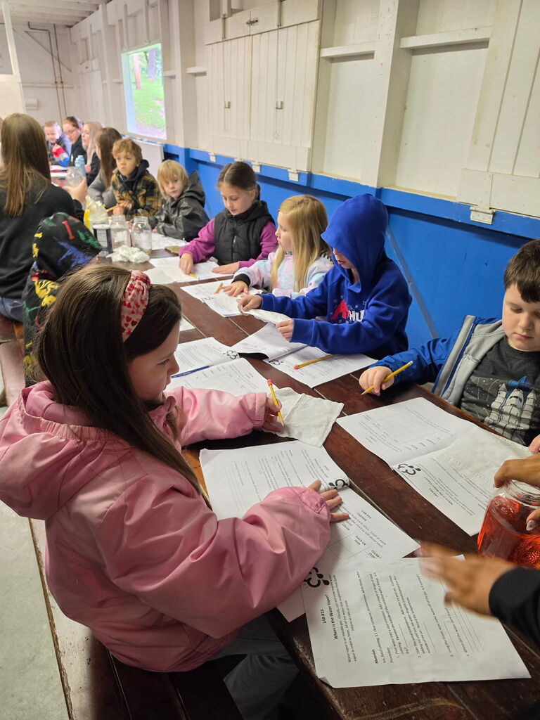 Hubbard second grade students participate in outdoor science activities at Harding Park with help from high school Ecology Club students.