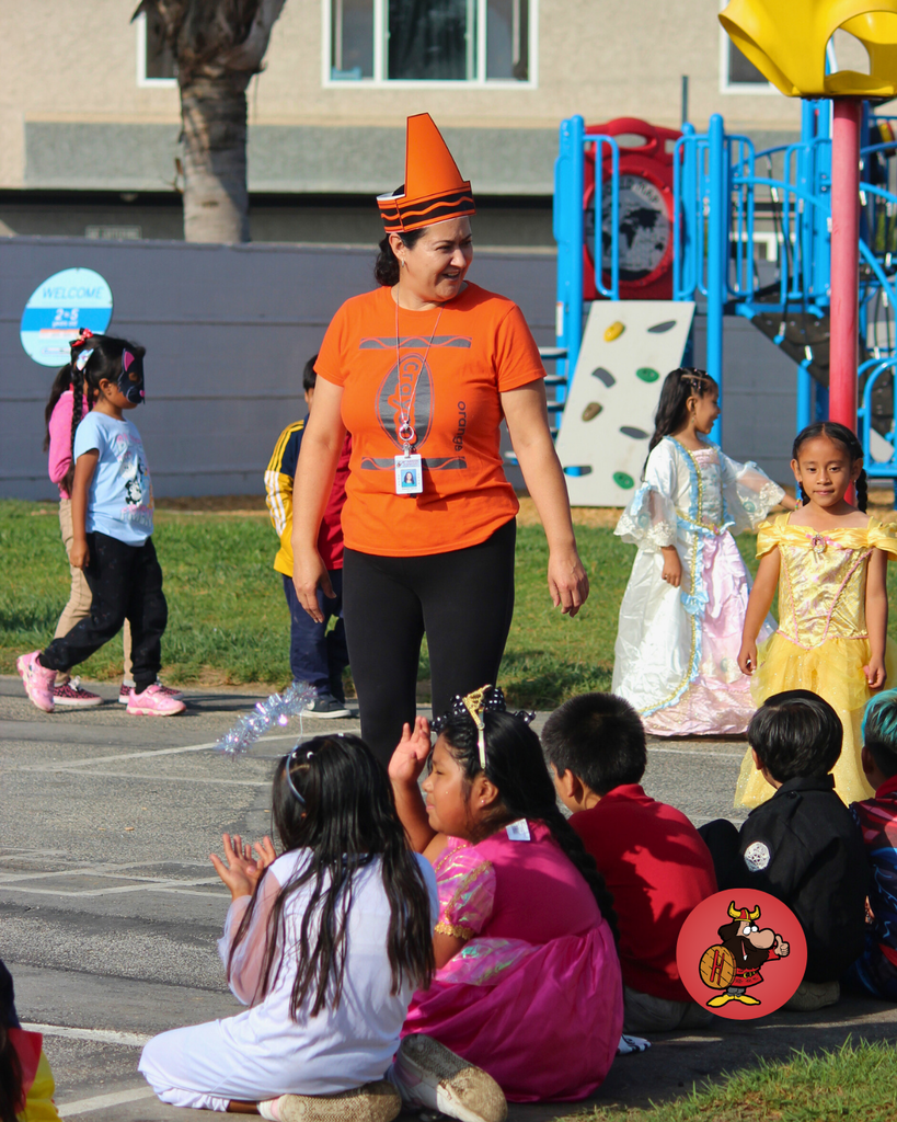kids and teacher dressed in costumes celebrating Halloween