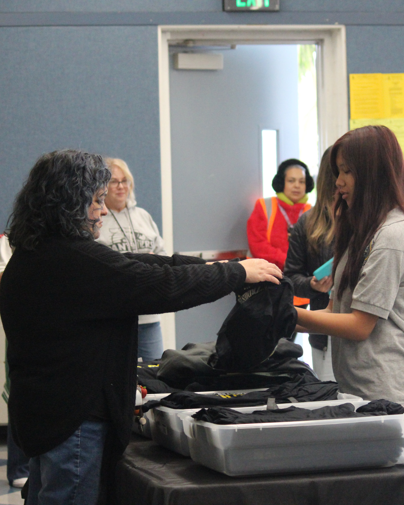 teacher giving student tshirt